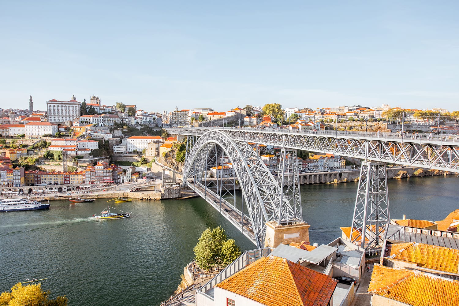 Vedere peisagistica a orasului vechi frumos cu faimosul pod de fier deasupra raului Douro in timpul apusului in orasul Porto, Portugalia